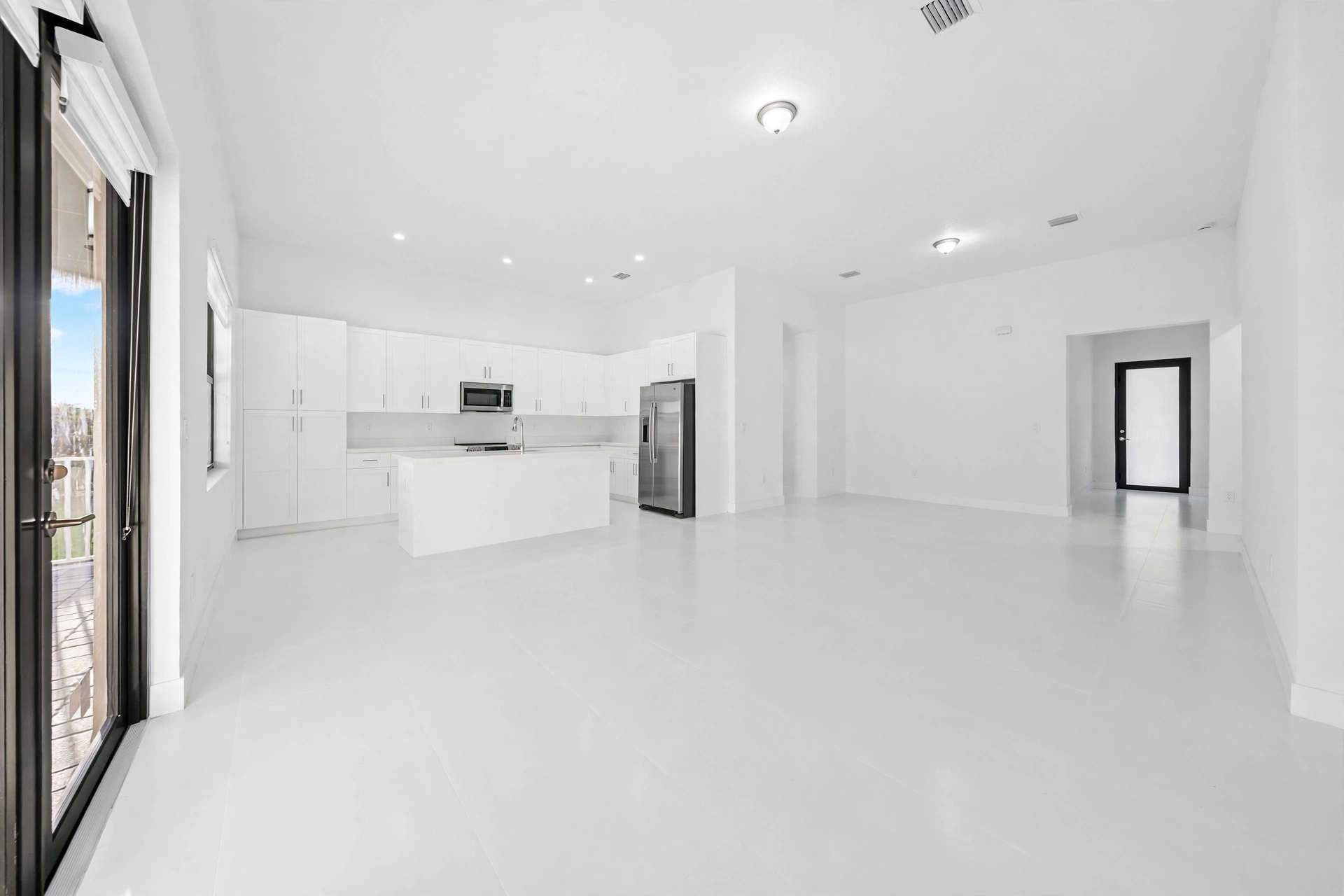 Empty open concept kitchen and living room before virtual staging